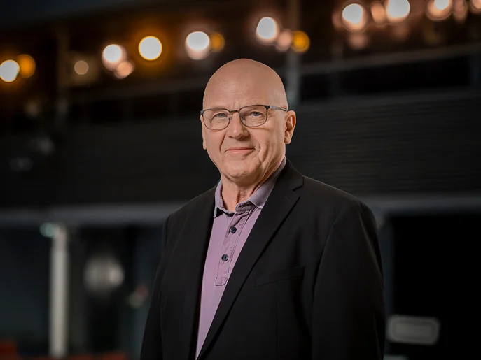 Intendant der Landesbühnen Sachsen mit schwarzen Anzug im Theatersaal.