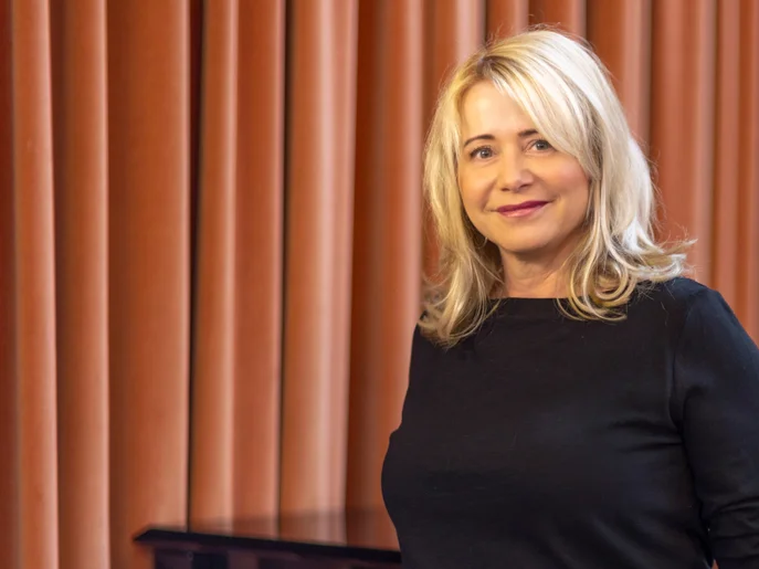 Geschäftsführerin der Elbland Philharmonie Sachsen in schwarzem Pullover vor roten Vorhang.