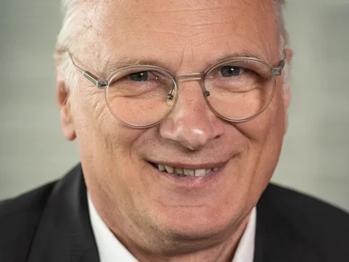 Lutz Hillman im Anzug mit Hemd vor neutralem Hintergrund