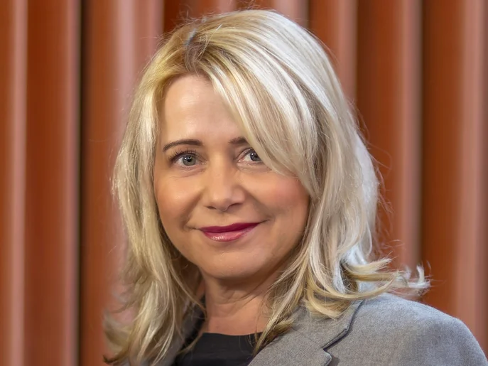 Geschäftsführerin der Elbland Philharmonie Sachsen in grauem Anzug vor roten Vorhang.