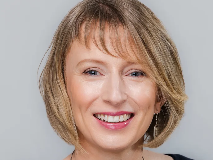 Verwaltungsdirektorin der Oper Leipzig mit kinnlangem, leicht gewelltem Haar und dunklem Oberteil, eine feine Halskette sichtbar.