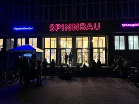 Außenansicht des Spinnbau-Gebäudes in Chemnitz bei Nacht mit Teilnehmenden.