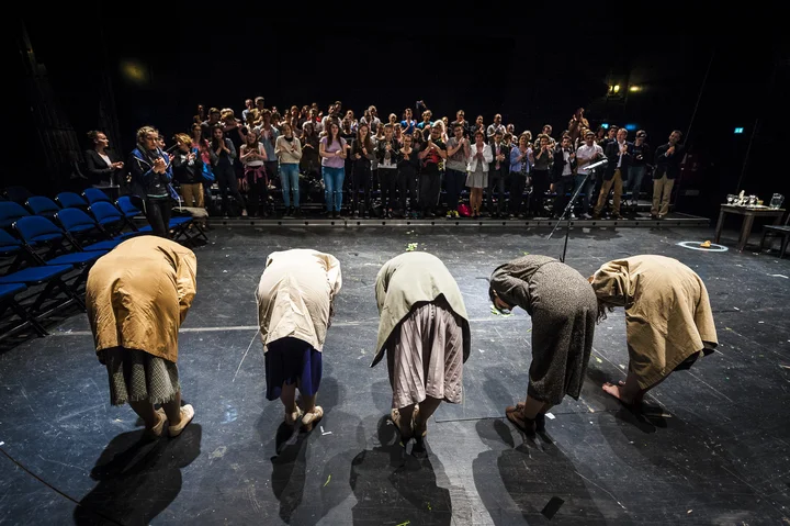 Beim J-O-Ś-Festival - Fünf Personen in unterschiedlicher Kleidung verbeugen sich auf einer Bühne vor einem applaudierenden Publikum.